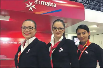  ??  ?? Chanelle Cilia, Martina Agius and Abigail Magro from Air Malta’s passenger handling section proudly wearing pink ribbons to celebrate Breast Cancer Awareness Month