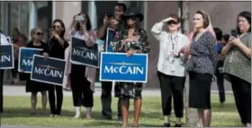  ?? JAE C. HONG — THE ASSOCIATED PRESS ?? People watch a motorcade carrying the casket of Sen. John McCain, R-Ariz., as it travels from the Arizona Capitol to the North Phoenix Baptist Church for a memorial service on Thursday in Phoenix.