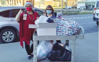  ?? (Special to The Commercial) ?? Sarah Payton (right), president of the Willing Workers of White Hall Extension Homemakers Club, delivers blankets to UAMS
Volunteer Services Coordinato­r Marcia Dunbar earlier this month in Little Rock.