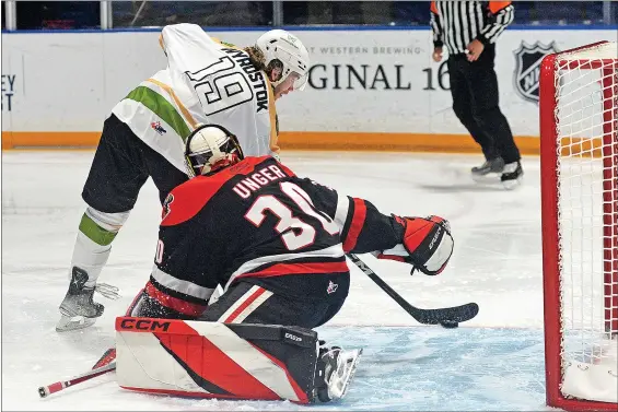  ?? STEVEN MAH/SOUTHWEST BOOSTER ?? Caleb Wyrostok scored on the backhand past Jackson Unger during the Lake Diefenbake­r Slough Sharks 4-0 win over the Moose Jaw Warriors.