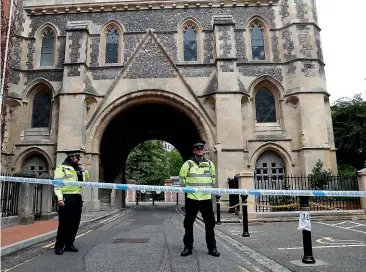  ?? AP ?? Police stand guard at the Abbey gateway of Forbury Gardens, which was the scene of a multiple stabbing attack in the gardens in Reading at the weekend.