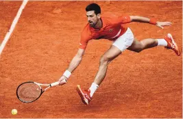  ?? THIBAULT CAMUS/ASSOCIATED PRESS ?? Novak Djokovic of Serbia lunges for a forehand during his third-round match at the French Open last Friday. Djokovic takes on rival Rafael Nadal in Tuesday’s quarterfin­als.