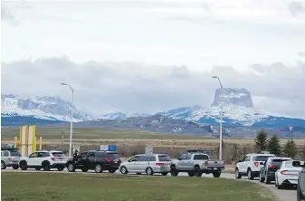  ?? IRIS SAMUELS, THE ASSOCIATED PRESS ?? Canadians drive to the Piegan-Carway border to receive COVID-19 vaccine from the Blackfeet tribe near Babb, Montana. Chief Mountain, sacred to the Blackfeet tribe, is in the background. The Blackfeet tribe gave out surplus vaccines to its First Nations relatives and others from across the border.