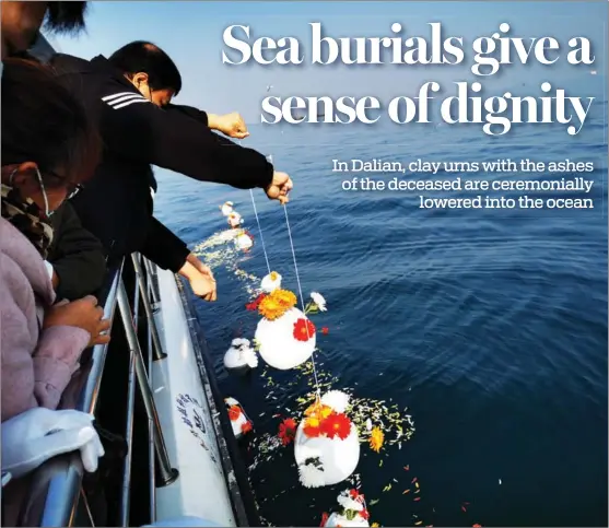  ?? ZHANG XIAOMIN / CHINA DAILY ?? Urns are placed in the sea during the mass burial. Such ceremonies have been promoted by the authoritie­s in Liaoning since 1997.