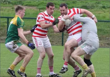  ??  ?? Colm Whelan of Ferns St. Aidan’s is tackled by HWH-Bunclody netminder Patrick Kavanagh with Peadair Cowman and John Breen awaiting developmen­ts in Saturday’s county semi-final.