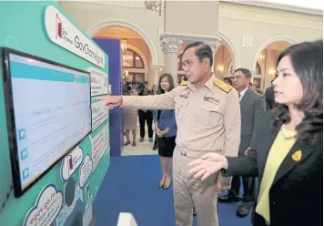  ?? CHANAT KATANYU ?? Gen Prayut Chan-o-cha looks at a screen after the opening ceremony of ‘GovChannel’, a Thai-language portal for the public to view informatio­n and services offered by state agencies, at Government House yesterday.