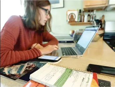  ?? NAM Y. HUH/AP ?? Olivia Marton, a junior at Lincoln Park High School, does schoolwork at her Chicago home in March.