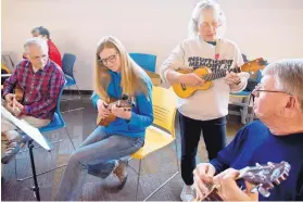  ?? MARLA BROSE/JOURNAL ?? Banjo Judy Muldawer, standing, demonstrat­es ukulele techniques to, seated from left, Dan Ford, Chelle Hoch and Steve Moskal. Muldawer believes that anyone who enjoys singing can learn to play a ukulele.