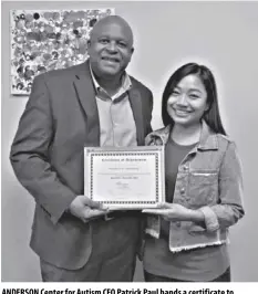  ?? ?? anderson center for autism ceo Patrick Paul hands a certificat­e to Patricia for completing her training program