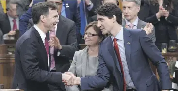  ?? ADRIAN WYLD / THE CANADIAN PRESS ?? Prime Minister Justin Trudeau shakes hands with Finance Minister Bill Morneau following his federal budget speech Tuesday in the House of Commons.