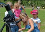  ??  ?? Jocelyn Heverly looks at the sun through the telescope at the picnic at Souderton Community Park Saturday, Aug. 4.