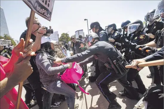  ?? Marcus Yam Los Angeles Times ?? PROTESTERS and police clash Friday. “We played, for years, the role of trying to f it into this model minority. We’re still not getting accepted,” said one activist.