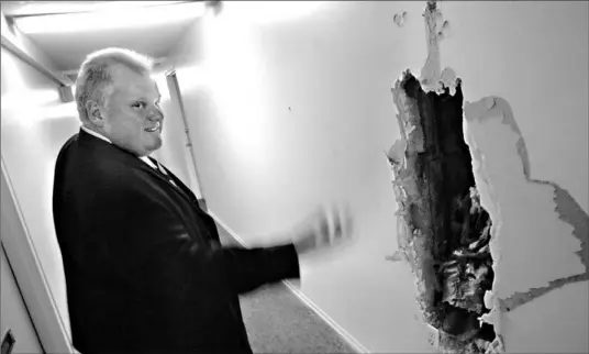  ?? LUCAS OLENIUK/TORONTO STAR ?? Councillor Rob Ford, who took a reporter on a tour of 75 Tandridge Cres. yesterday, checks a gaping hole in the wall. The apartment complex is in need of extensive repair.
