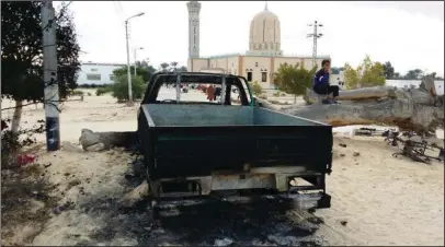  ?? The Associated Press ?? AL-RAWDA MOSQUE: A burned truck is seen outside Al-Rawda Mosque on Nov. 25 in Bir al-Abd northern Sinai, Egypt, a day after attackers killed hundreds of worshipper­s. The Egypt mosque massacre could point to the rise of an ultra-extremist faction that...