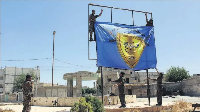  ?? FOTO: AP/NTB SCANPIX ?? JAGET BORT IS: Den kurdisk-ledede opprørsall­iansen SDF, som kjempet mot IS sammen med USA, heiser alliansens flagg i byen Manbij etter å ha jaget IS på flukt i august 2016. Det er uklart hva USA vil gjøre hvis tyrkiske styrker angriper den...