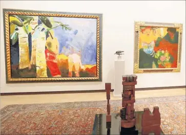  ?? Photograph­s by Allen J. Schaben Los Angeles Times ?? JOAN BROWN’S “People and Eye Trees in the Park in Madrid,” left, razzes a struggle between abstract and figurative painting in 1961, the time it was made. Elmer Bischoff’s “Late Afternoon” (1953) hangs beside it.