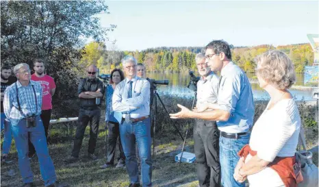  ?? FOTOS: CHRISTOPH KLAWITTER ?? Andre Baumann (Zweiter von rechts) gefällt der Vogelsee (im Hintergrun­d). Bei seinem Besuch tauscht er sich mit Naturschüt­zern und Lokalpolit­ikern aus.
