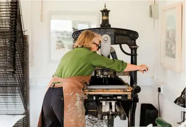  ??  ?? Angela works her toggle-action Albion printing press, with its distinctiv­e ‘crown’ finial. They were used for commercial book printing until the mid 19th century (left). The paper is removed from the lino to reveal the transferre­d design (right).