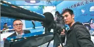  ?? KUANG LINHUA / CHINA DAILY ?? An exhibitor from BeiDou Changsha in Hunan province displays an electric gun during an industry expo in Beijing.