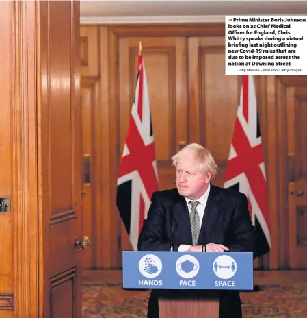  ?? Toby Melville – WPA Pool/Getty Images ?? Prime Minister Boris Johnson looks on as Chief Medical Officer for England, Chris Whitty speaks during a virtual briefing last night outlining new Covid-19 rules that are due to be imposed across the nation at Downing Street