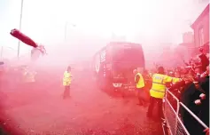  ??  ?? Liverpool fans set off flares and throw missiles at the Manchester City team bus outside the stadium before the Champions League Quarter Final First Leg match in Liverpool April 4, 2018. - Reuters photo