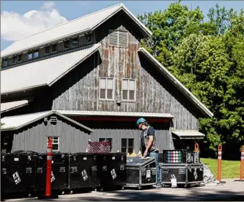  ?? Karli Cadel / The Glimmergla­s Festival ?? Workers unpack material to build the outdoor stage at Glimmergla­ss earlier this summer.