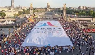  ?? AFP ?? People carry a giant banner with the logo of the Paris bid for the 2024 Olympic Games last month. —