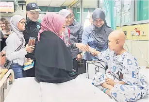  ?? — Gambar Bernama ?? TIDAK DILUPAKAN: Nadzim (dua kiri) bersama Srizan (tiga kiri) beramah mesra bersama Zulaliff (kanan) semasa mengadakan lawatan ke Institut Pediatrik Hospital Kuala Lumpur di ibu negara semalam.