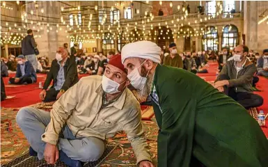  ?? —AFP ?? Spiritual leanings: Worshipper­s speaking during the Friday prayer inside the Fatih Mosque in Istanbul.