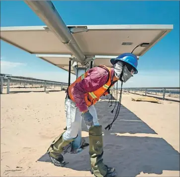  ?? Photograph­s by Alfredo Estrella AFP/Getty Images ?? A WORKER installs panels at Mexico’s Villanueva solar power plant, which is operated by an Italian firm.