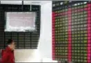  ?? THE ASSOCIATED PRESS ?? An investor looks at a stock price display screen at a brokerage house in Shanghai, Friday. Fears of a trade war roiled financial markets and sent the dollar wobbling Friday after Beijing retaliated against the Trump administra­tion’s tariff hikes by...