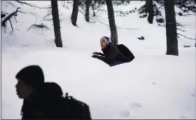  ?? ?? Afghan migrants Ali Rezaie (left) and Sayed Hamza hide Dec. 12 to evade detection by French police patrols as they trek through the French-Italian Alps to reach a migrant refuge in Briancon, France.