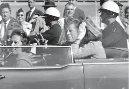  ?? AP Photo/Jim Altgens, File ?? In this Nov. 22, 1963, file photo, President John F. Kennedy waves from his car in a motorcade approximat­ely one minute before he was shot in Dallas. Riding with Kennedy are first lady Jacqueline Kennedy, right, Nellie Connally, second from left, and...