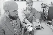  ??  ?? University of Florida computer science graduate students Nolen Scaife, left, and Christian Peeters demonstrat­e the “Skim Reaper,” a device that can be used to detect illegal credit card “skimmers” on ATMs and gas pumps.