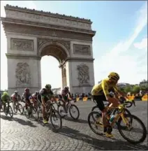  ?? MICHAEL STEELE, GETTY IMAGES ?? Chris Froome of Great Britain (yellow jersey) and the rest of the peloton cycle past The Arc de Triomphe in Paris on Sunday.