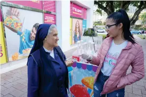  ?? The Associated Press ?? ■ Sister Consuelo Gómez, left, talks with Daniela Valletero, a Venezuelan migrant that Gomez helped settle in her new U.S. life, on Feb. 20 in Miami. Valletero and her younger sister met Gómez when they went to mass at La Ermita, a shrine to Our Lady of Charity, that’s long been the first stop for many fleeing Latin American countries. Many migrants go to the church to thank the Virgin Mary for safe passage and a chance for a better life in Florida.