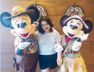  ??  ?? Meeting the explorers: Author Gabbie Tatad in a character greeting with Mickey and Minnie decked out in their o cial explorer duds.