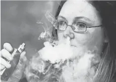  ?? RON JOHNSON, AP ?? Stephanie Wilson of Breathe Vapor exhales e- cigarette smoke.