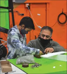  ??  ?? Nine-year-old Ari Parmar receives some guidance with the building of his Styrofoam plane from dad Vim Parmer, who helped to facilitate the inaugural Swift Current Creation Station event, Jan. 9.