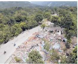  ?? MATIAS DELACROIX/AP ?? Destroyed homes stretch along a quake-damaged road Wednesday in Rampe, Haiti. The quake and a tropical storm added to the misery in the impoverish­ed country.