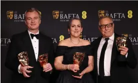  ?? ?? Cleaning up … Christophe­r Nolan, winner of the awards for director and best film for Oppenheime­r, with producers Emma Thomas and Charles Roven with their awards. Photograph: Hollie Adams/Reuters