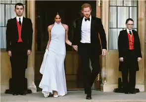  ?? Steve Parsons/ AFP/ Pool ?? Merghan Markle e o príncipe Harry saindo do Castelo de Windsor para a segunda recepção do casamento no sábado à noite: vestido assinado por Stella McCartney