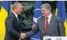  ?? - Reuters ?? DETERMINED: NATO Secretary General Jens Stoltenber­g and Ukrainian President Petro Poroshenko shake hands during a joint news conference in Kiev, Ukraine, on Monday.