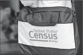  ?? [JOHN RAOUX/ THE ASSOCIATED PRESS] ?? A briefcase of a census taker is seen as she knocks on the door of a residence Aug. 11 in Winter Park, Fla.