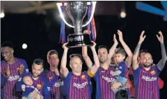  ?? AFP ?? Andres Iniesta lifts the La Liga trophy after his last game for Barcelona on Sunday.