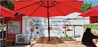  ?? Photos by Alison Cook/Staff ?? The tables on the patio at Villa Arocs are topped with bright red umbrellas.