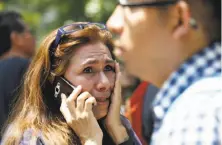  ??  ?? A woman tries to reach people on her cell phone after she fled with others to Reforma Avenue when the earthquake struck.