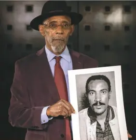  ??  ?? Gesture of solidarity … Linton Kwesi Johnson holds a portrait of Amanuel Asrat.