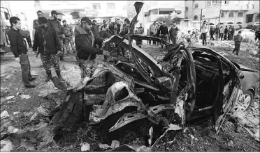  ?? MOHAMMED ABED, Afp/getty Images ?? A Hamas police officer inspects the remains of a vehicle after it was targeted by an Israeli air strike
that killed the head of the Popular Resistance Committees militant group in Gaza City on Friday.