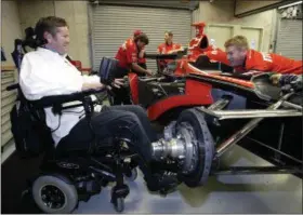  ?? TOM STRATTMAN — THE ASSOCIATED PRESS FILE ?? In this Friday file photo, Indy Racing League car owner Sam Schmidt, left, talks with crew member Mike Sobeleski as he works on the car in the garage area at the Indianapol­is Motor Speedway. Sam Schmidt was left quadripleg­ic from a racing accident and the team he later created has suffered a series of tragedies and setbacks.